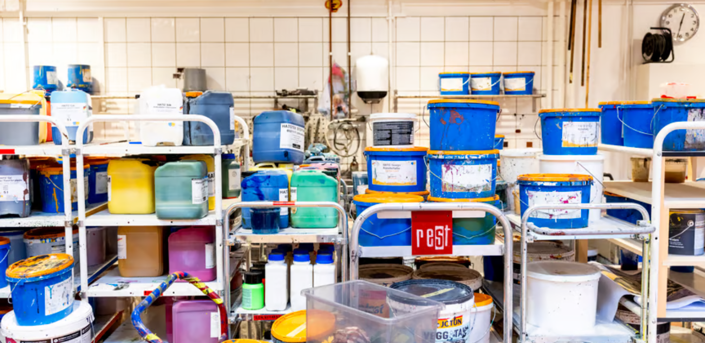Bildet viser flere ulike fulle og tomme malingspann i en verktøyhall hos et norsk teater.